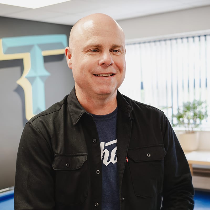 Smiling bald man in black jacket in modern office