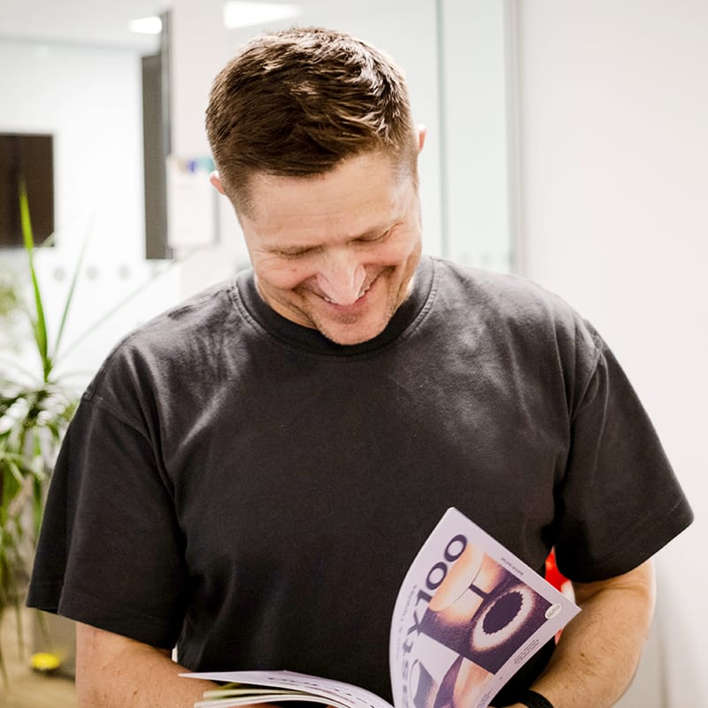 Man smiling whilst reading a magazine in an office