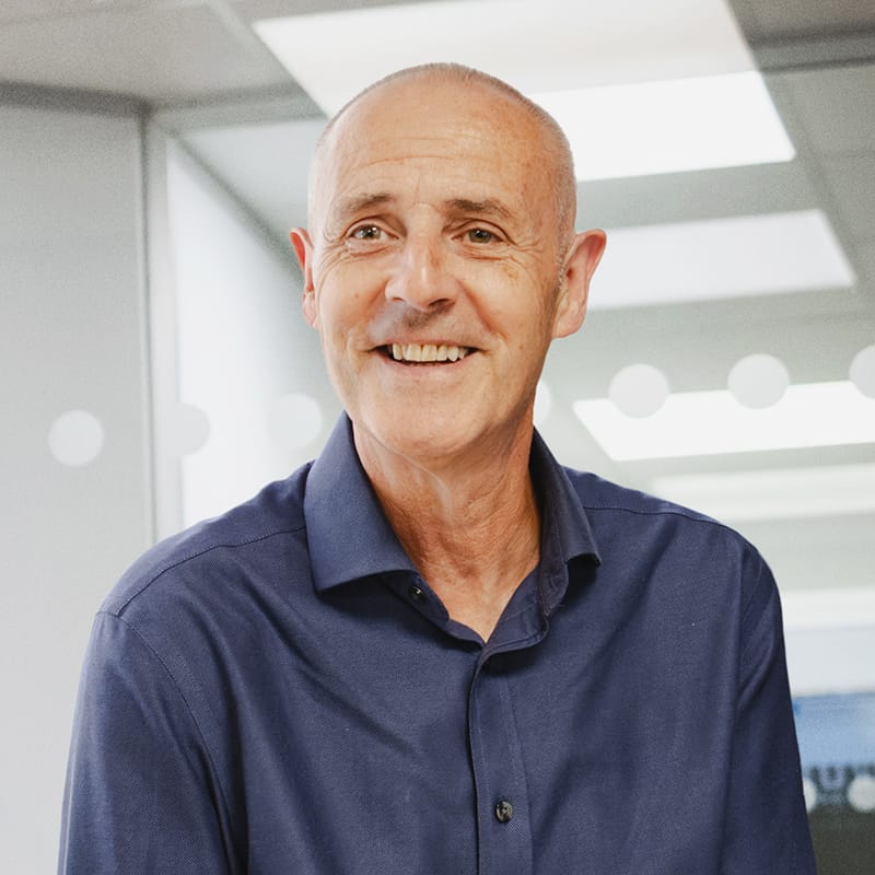 Smiling middle-aged man in navy shirt in modern office