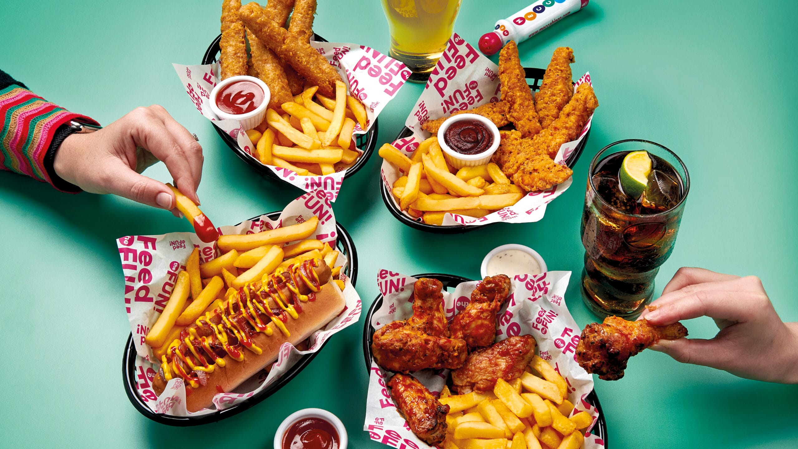 Sharing spread of chicken strips, wings, hot dog and fries